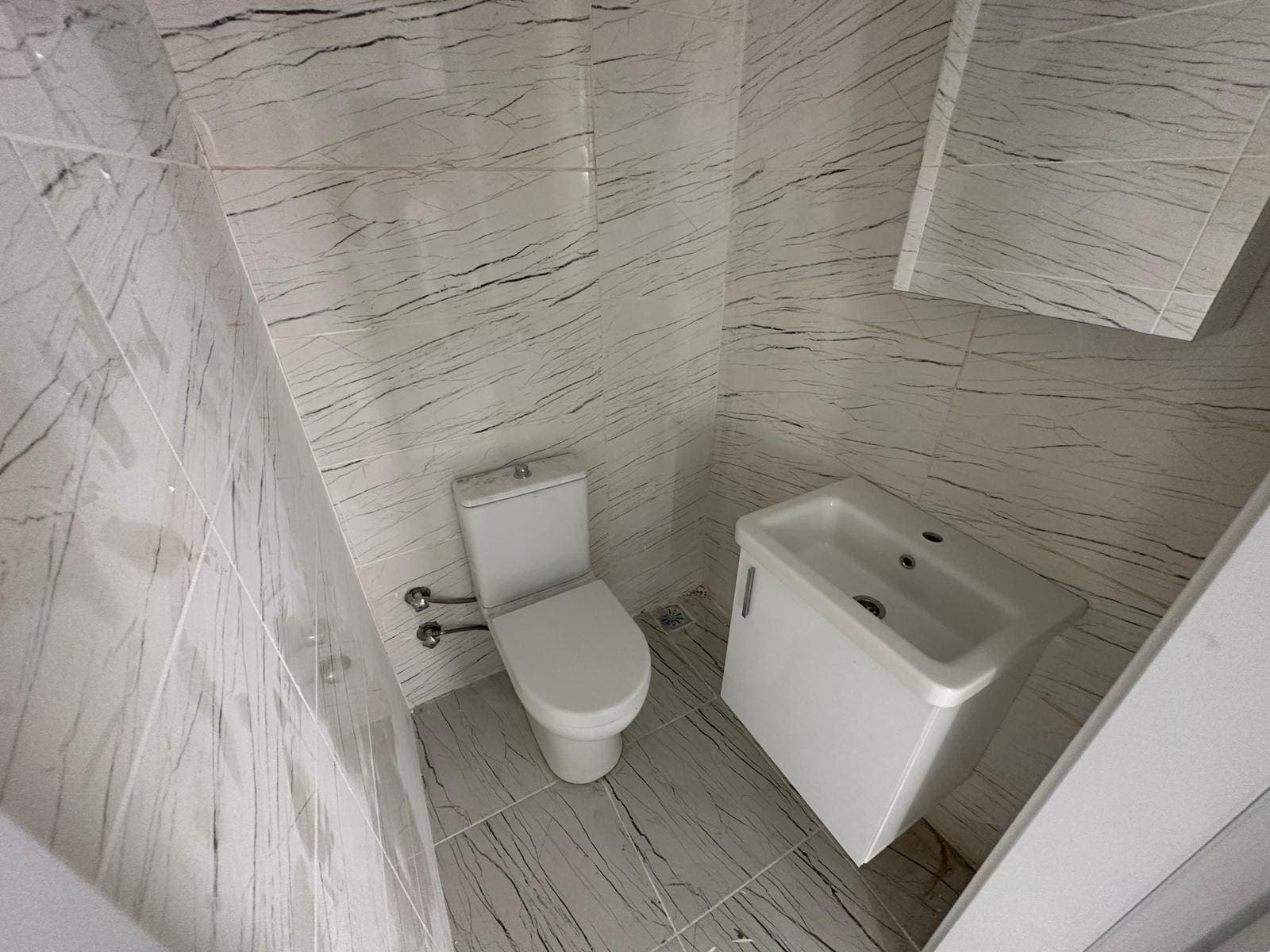 Beyaz mermer görünümlü seramik kaplı banyo